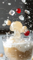 Splashing Milk with Ice Cubes and Cherries in a Glass