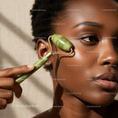 Beautiful African Woman Using Jade Roller for Facial Skincare