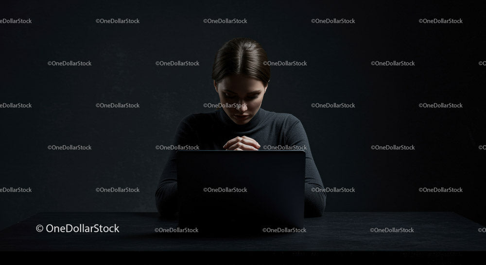 Thoughtful Woman at Laptop in Dark Modern Workspace