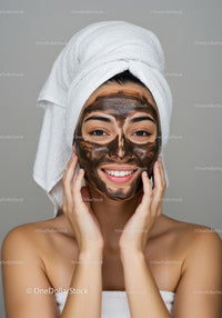 Young Woman with Facial Mask and Towel Wraps in Spa Setting