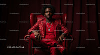 Confident Man in a Bold Red Suit Sitting Elegantly