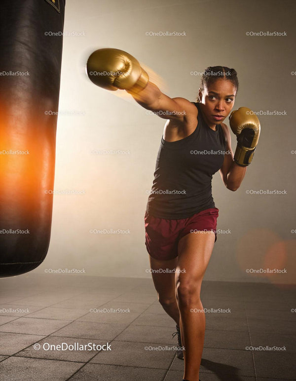 Focused Athlete Training with Punching Bag in Gym