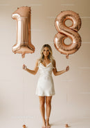 Young woman celebrating eighteenth birthday with balloons