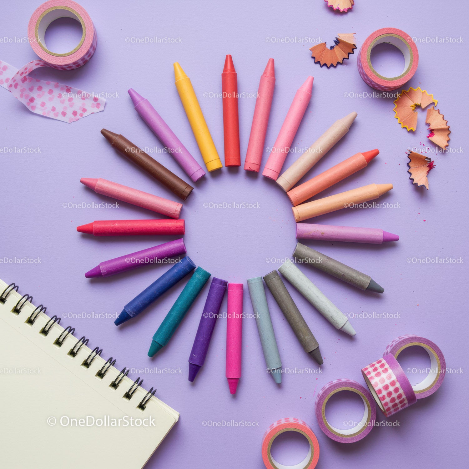 Colorful crayons arranged in a circle with art supplies