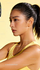 Focused young woman playing badminton indoors