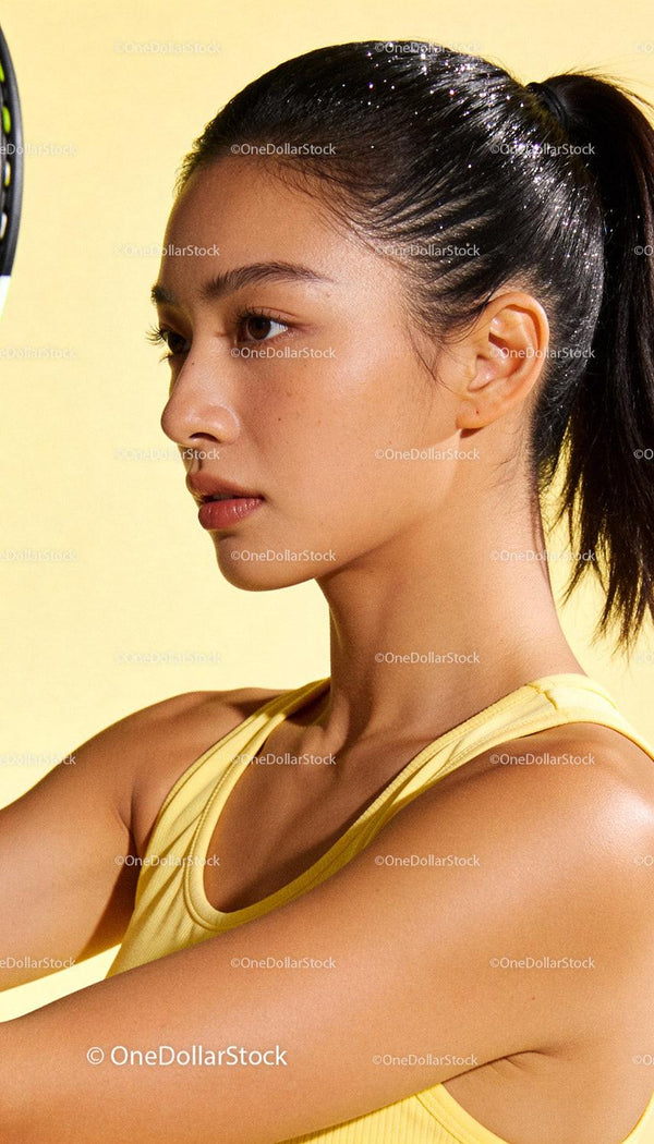 Focused young woman playing badminton indoors