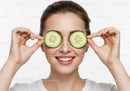 Joyful Woman Holding Cucumber Slices in Bright White Studio