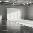 Empty photo studio with white backdrop and industrial interior