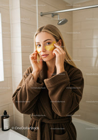 Woman Applying Under Eye Patches in Bathroom for Skincare Routine