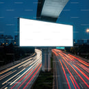 Illuminated blank billboard over busy city highway at dusk