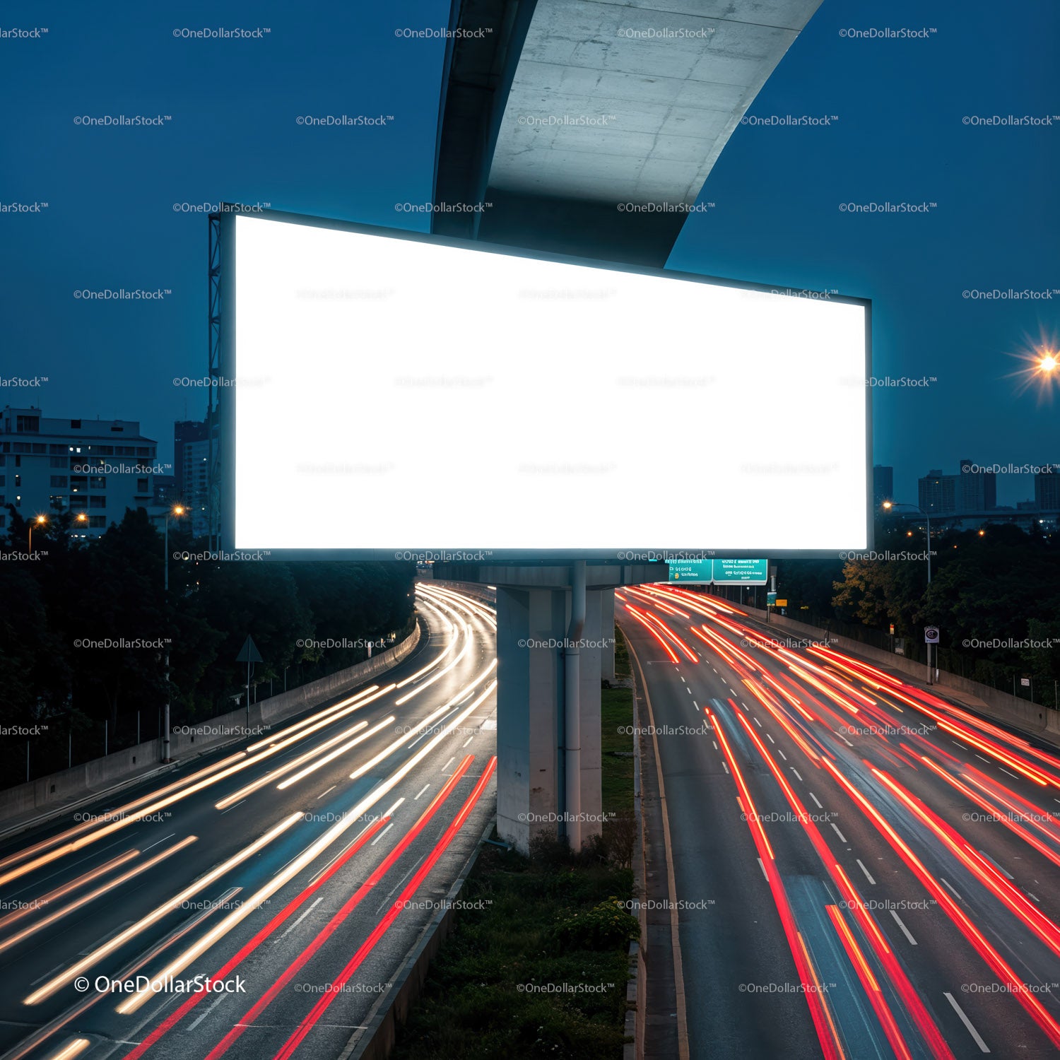 Illuminated blank billboard over busy city highway at dusk