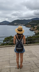 Woman wearing hat enjoying scenic coastal mountain view