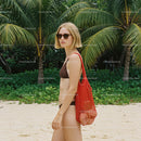 Stylish Woman in Bikini with Red Tote on Tropical Beach