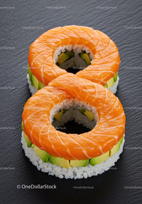 Fresh salmon avocado sushi rings on slate plate