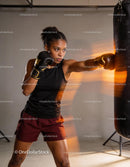 Focused female boxer delivering powerful punch in gym