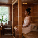 Relaxing Woman Sitting in Wooden Sauna with Towel in a Wellness Center