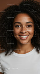 Portrait of a Smiling Woman with Curly Hair and Freckles in Casual Attire
