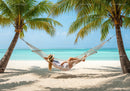 Tropical Beach with Hammock Between Palm Trees and Clear Blue Water