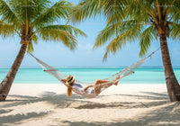 Tropical Beach with Hammock Between Palm Trees and Clear Blue Water
