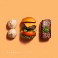 Gourmet Burger with Lettuce and Tomato Next to Grilled Steak and Dumpling