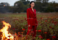 Confident woman in red suit standing in flower field