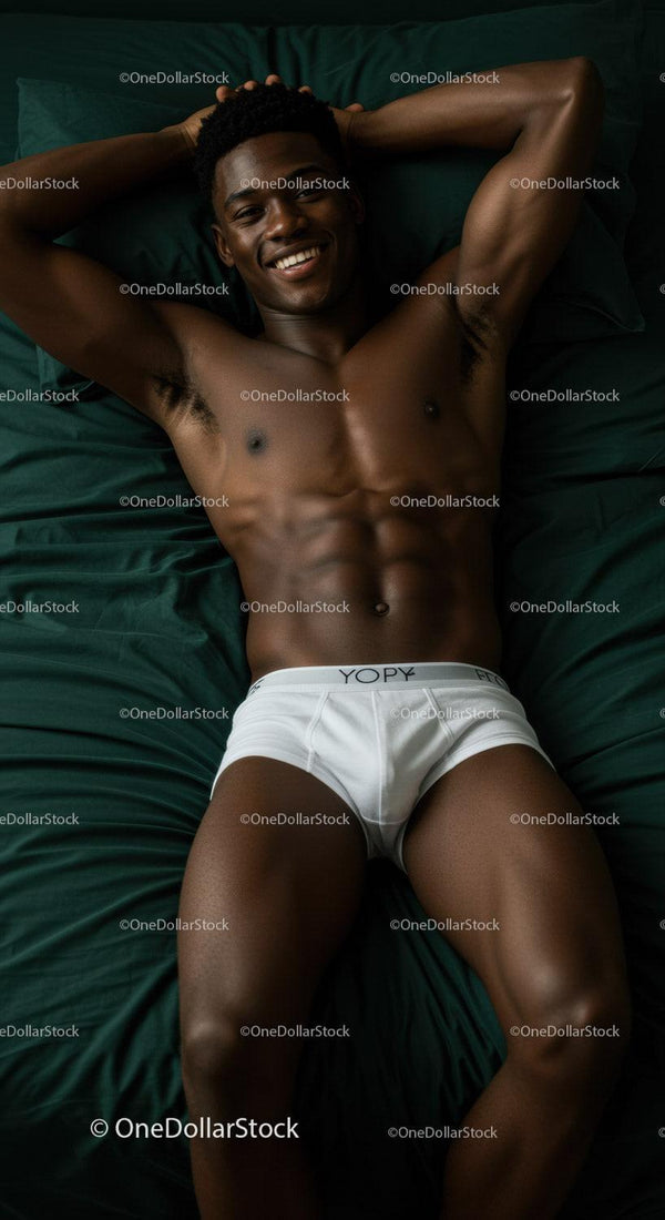 Smiling man relaxing in white briefs on dark green bedding