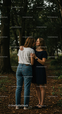 Couple sharing tender kiss in serene forest path