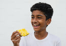 Joyful Young Boy Enjoying Pineapple Slice with Bright Smile
