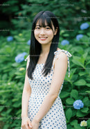 Young Woman in Polka Dot Dress Smiling in Garden with Hydrangeas