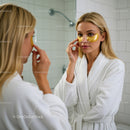 Young Woman Applying Under-Eye Patches in Bathroom Spa Setting