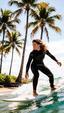 Woman Surfing Gracefully on Ocean Wave Near Palm Trees