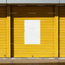 Bright yellow storefront with blank white poster