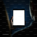Person Holding Bright Digital Tablet in Dark Room