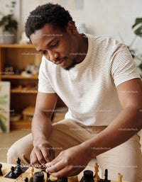 Focused young man playing chess in cozy living room
