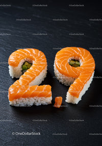 Sushi shaped as number twenty nine on black surface