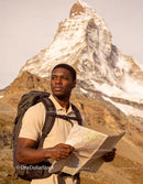 Hiker with Map Exploring Mountain Landscape at Sunrise