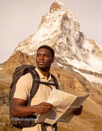 Hiker with Map Exploring Mountain Landscape at Sunrise