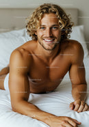 Smiling young man with curly hair lying on bed