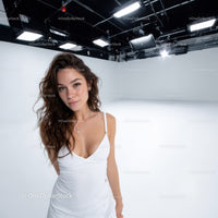 Young Woman in White Dress in Bright Studio with Soft Lighting