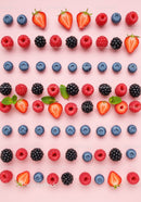 Colorful fresh berries and mint leaves on pink background
