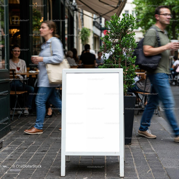 Blank sidewalk sign outside busy urban café JPG Mockup Image