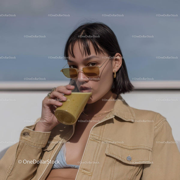 Stylish Woman Drinking Smoothie Outdoors Under Blue Sky