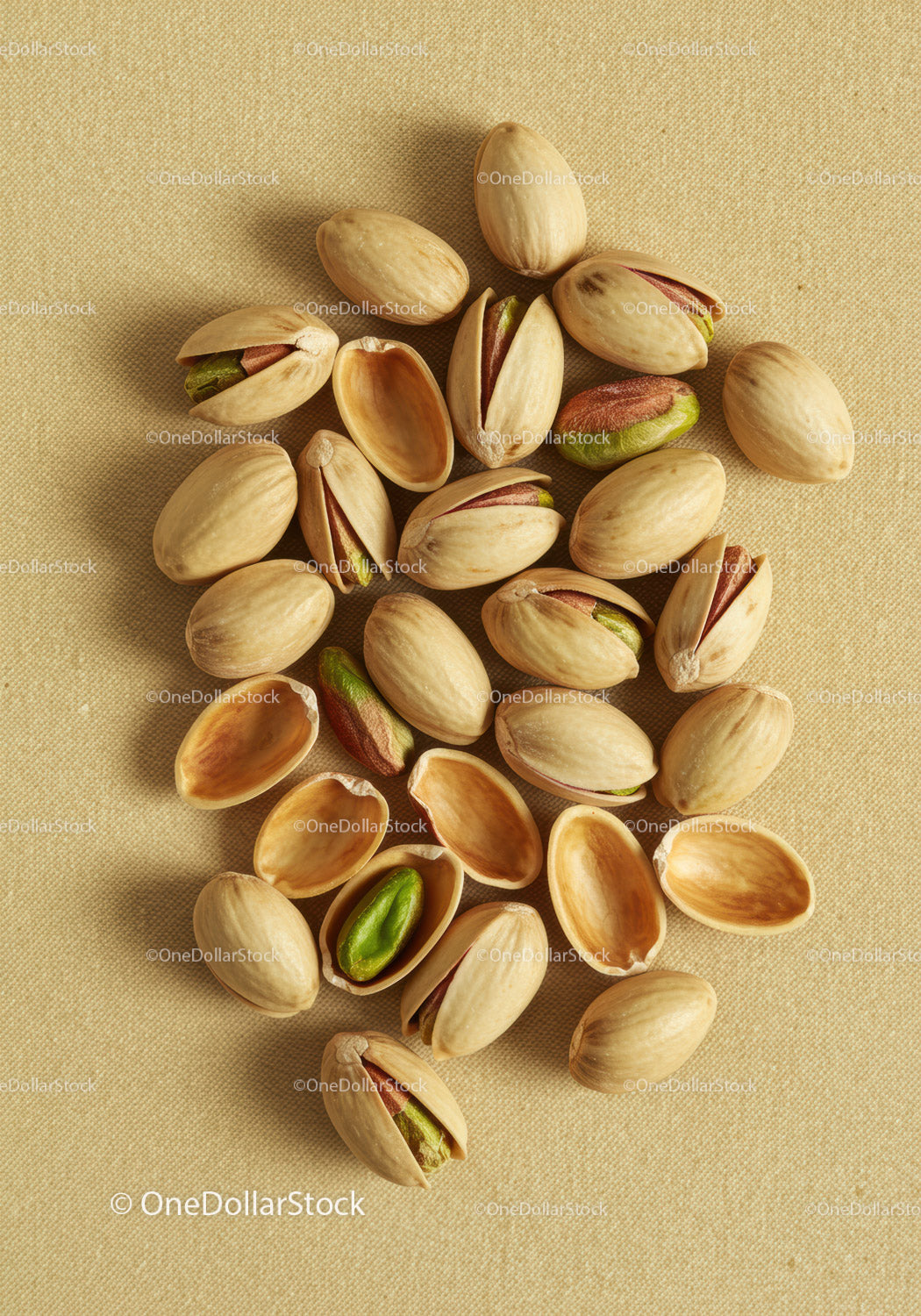 Close up of pistachio nuts on textured fabric background