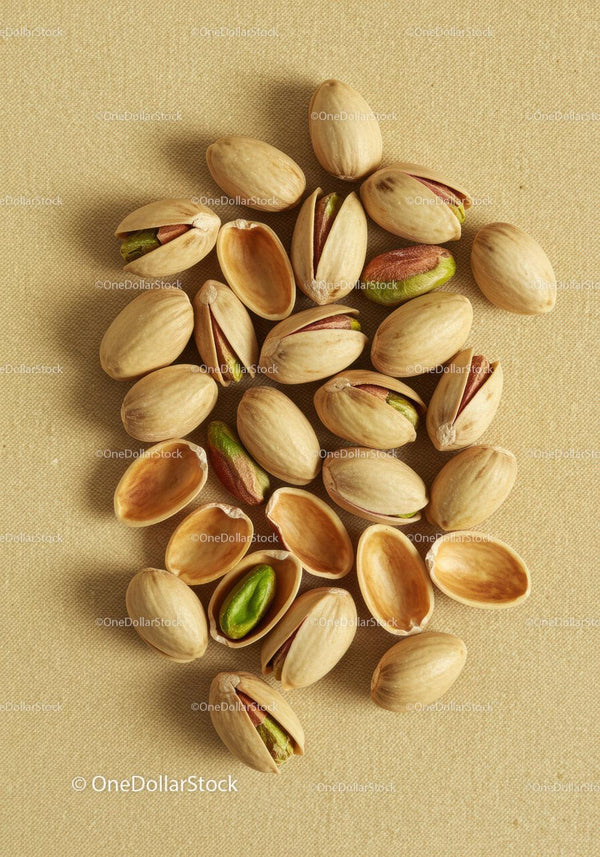 Close up of pistachio nuts on textured fabric background