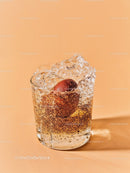 Glass of sparkling water with plum and ice cubes