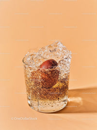 Glass of sparkling water with plum and ice cubes