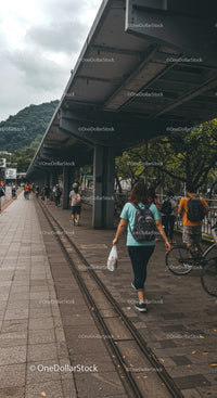 Busy Urban Street Scene with Pedestrians and Bicycle under Overpass