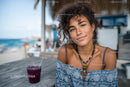 Young Woman Smiling at Beachside Cafe in Summery Outfit