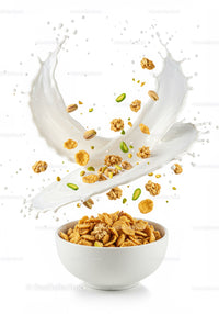 Crispy cereal with nuts splashing into fresh milk