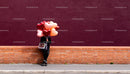 Person Holding Heart Balloons and Chocolates on Brick Wall